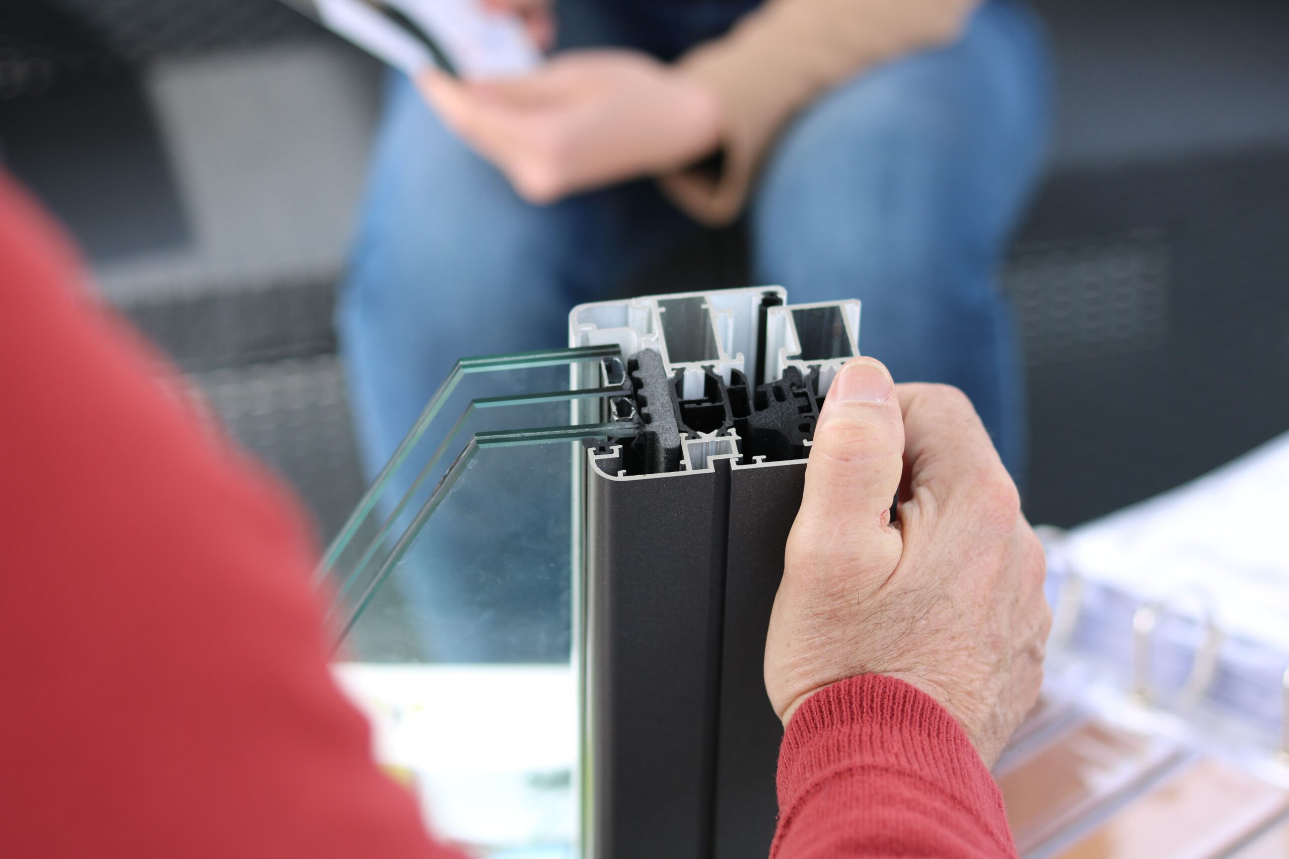 FedDev Ontario RTRI Funding: Up to $3 Million in Non-Repayable Support Close-up of hand holding an aluminum window frame sample, ideal for construction themes.
